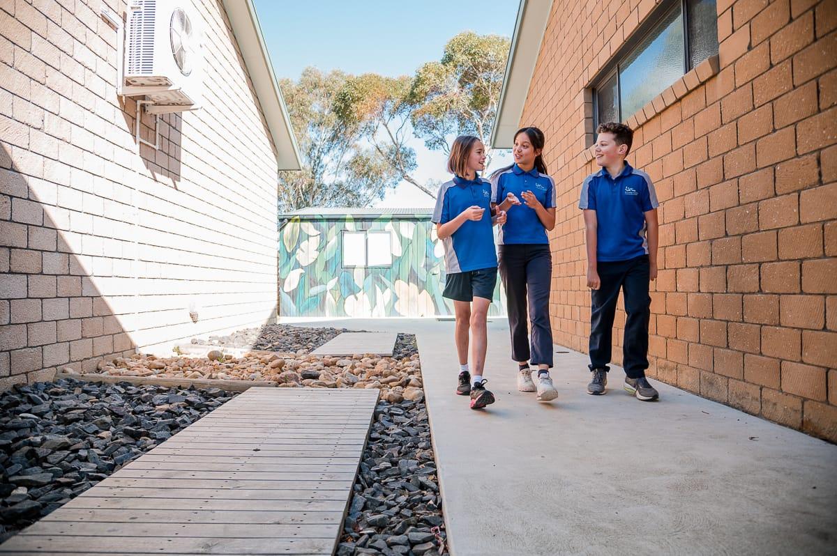 Female senior school captain smiling at primary school boy exemplifying caring cross-age mentoring